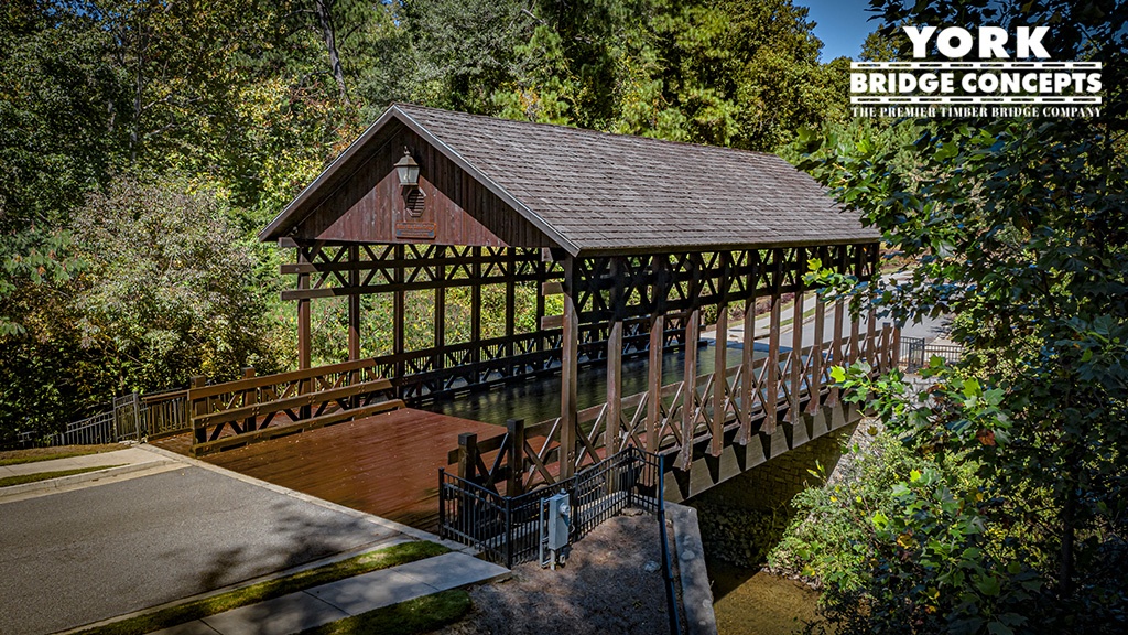 Aerial profile of the Woodbridge covered double lane vehicular with attached pedestrian timber bridge in Smyrna, GA